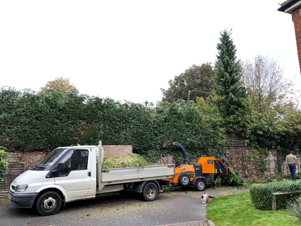 hedges being chipped with a grinder and van